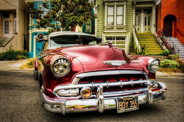 Retro cherry-colored car near houses professional photo