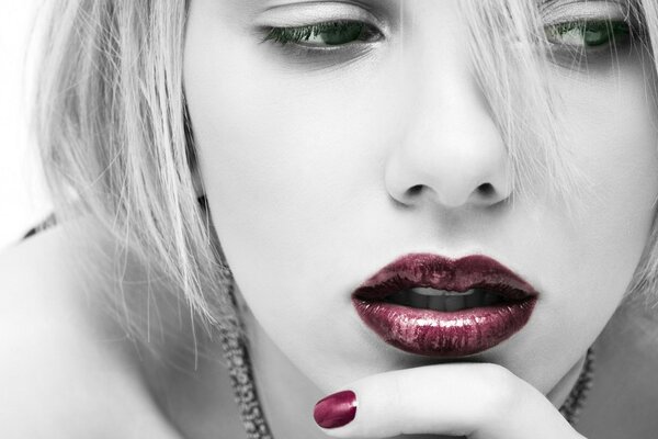 Scarlett Johansson en un fondo blanco y negro con labios y uñas brillantes