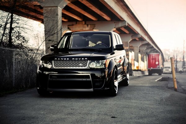 Black range rover under the overpass