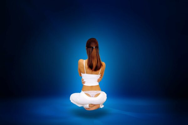 A meditating girl depicted from the back