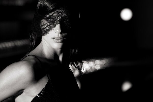 Beautiful girl in a dress and mask and night lights