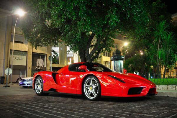 Ferrari potente nel crepuscolo di una grande città