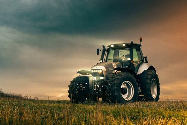 The tractor stands against a beautiful sky