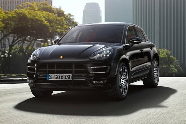 Black Porsche Macan on the background of the metropolis