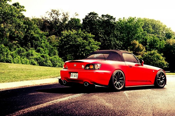 Honda s2000 en una pista larga cerca del bosque