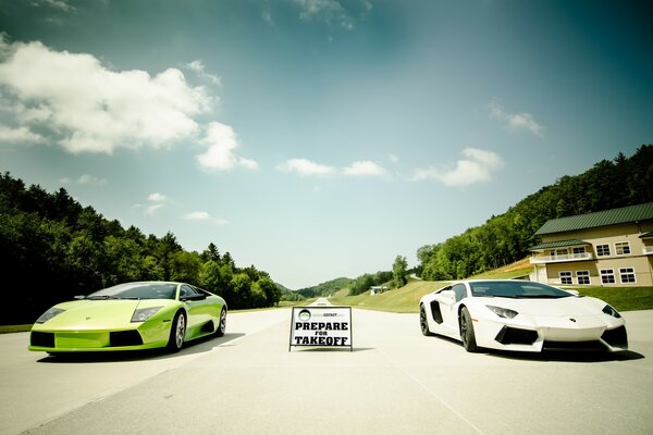 Dos superdeportivos lambirghini de color verde y blanco en la pista