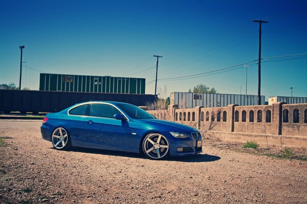 BMW bleue à côté du train et de la clôture