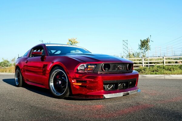 Rojo hermoso Mustang en el fondo de la naturaleza
