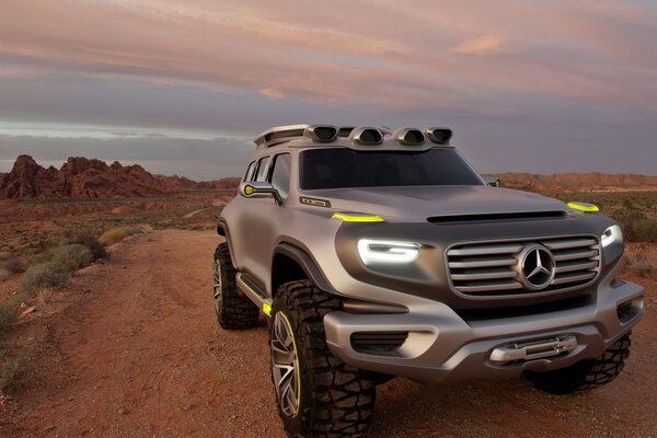 Mercedes benz en el desierto con las luces encendidas