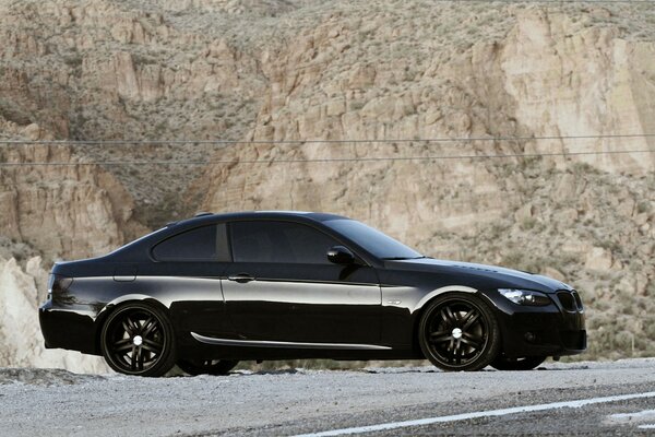 There was a black BMW parked on the rocks along the trail