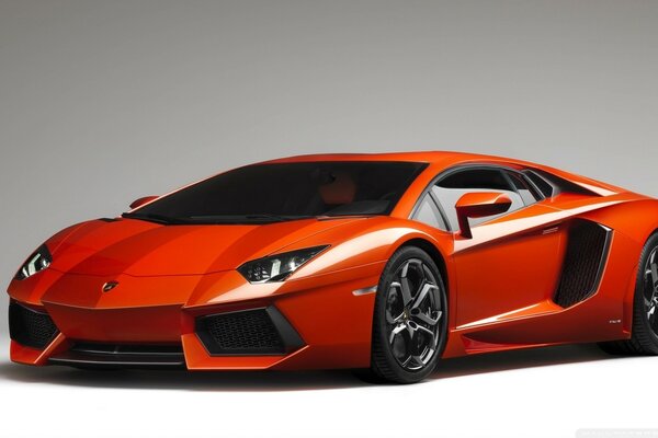 Pomarańczowy supersamochód lamborghini aventador na szarym tle