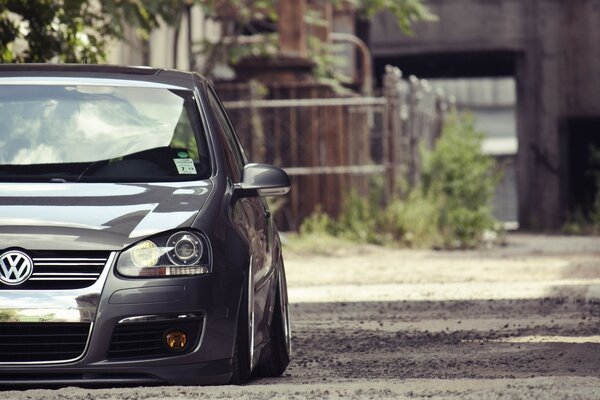 A black understated golf in half stands on the road