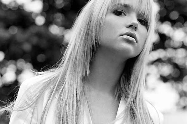 Blonde in a white blouse in black and white on a blurry background