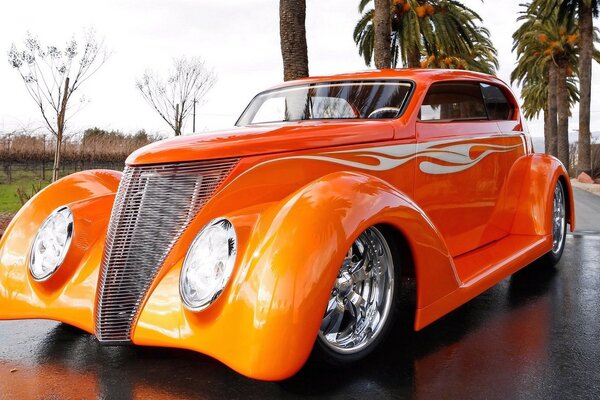 Coche Ford retro de color naranja en el fondo de las palmeras