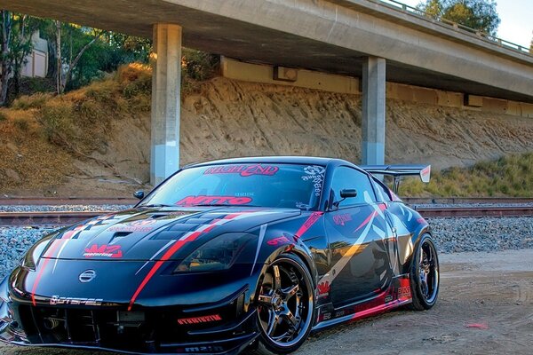 Sports car under the bridge by the railway