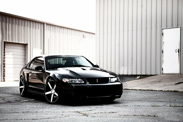 A black Ford Mustang with silver wheels