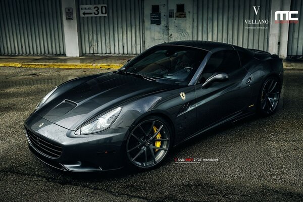 Grey Ferrari sports car in the parking lot in the industrial zone