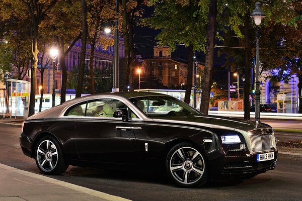 Black rolls-royce on the background of the night city