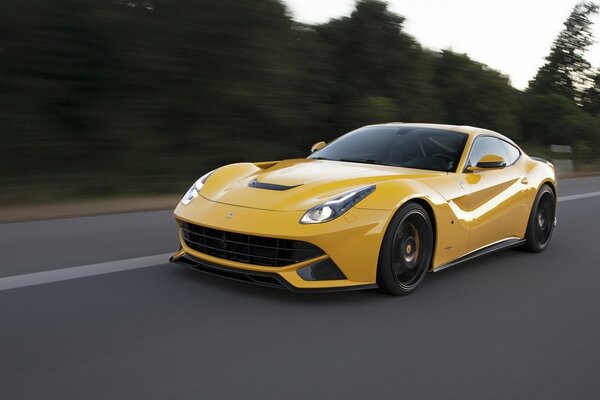 Yellow Ferrari car rushes along the highway