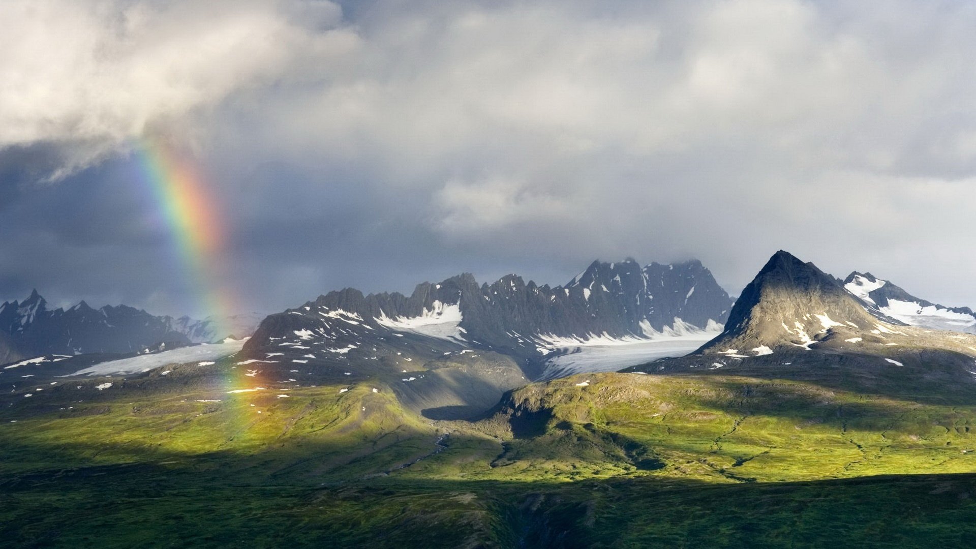 arcobaleno dopo la pioggia montagne nuvole cime prato pendii