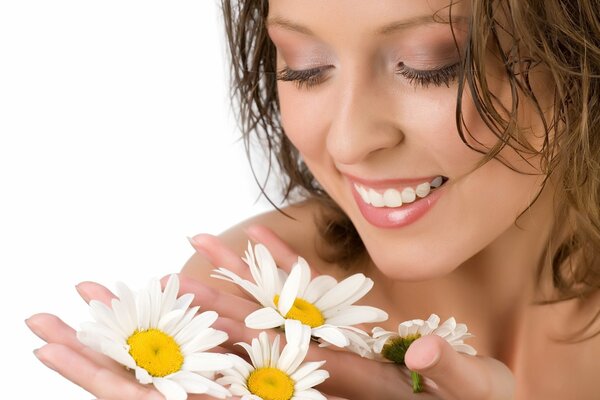 Fille douce avec des marguerites délicates dans les mains