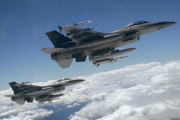 F-16 fighting falcon aircraft in flight above the clouds