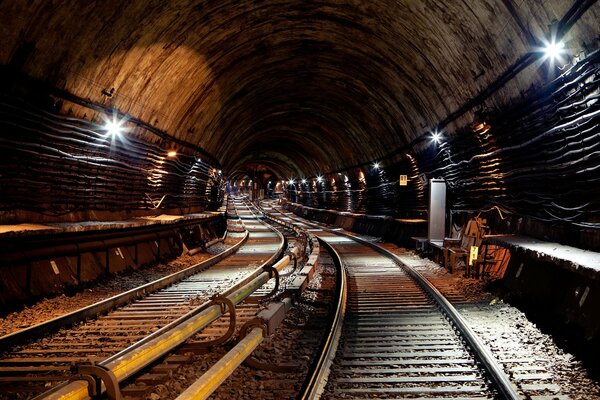 A tunnel with electricity and rails extending into the distance