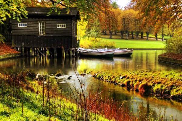 Autunno luminoso con una casa vicino all acqua e barche