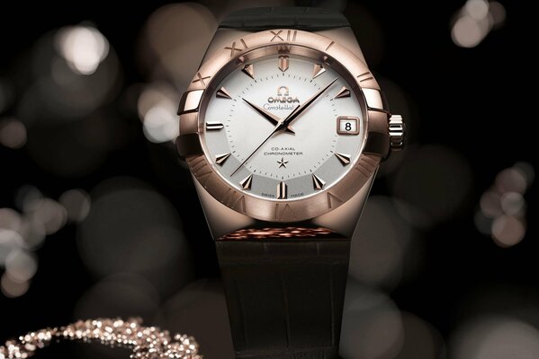 Swiss omega watch, against the background of glare and scattering of stones