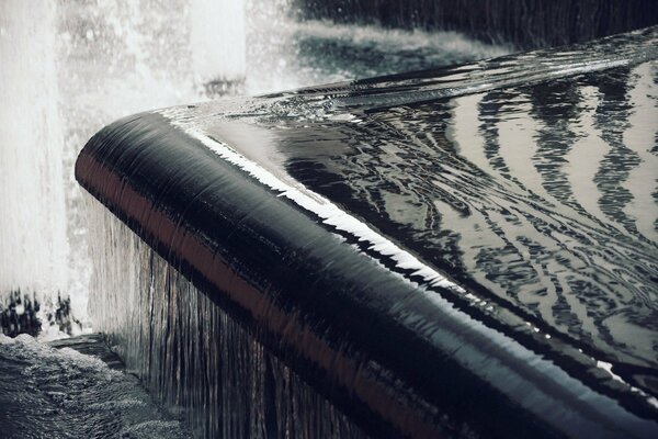 The threshold of the fountain bends and turns into a waterfall