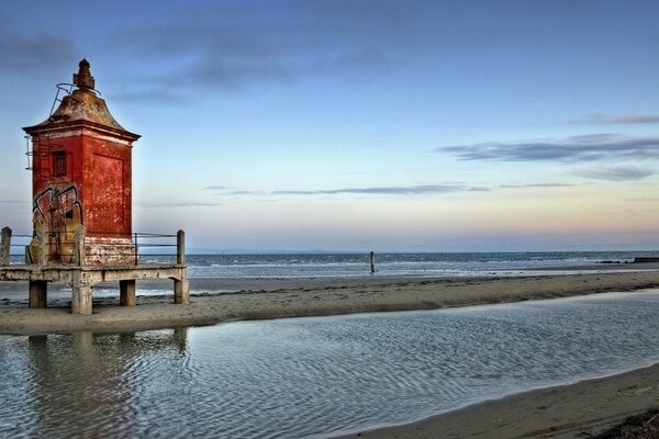 Meeresbucht und roter Leuchtturm