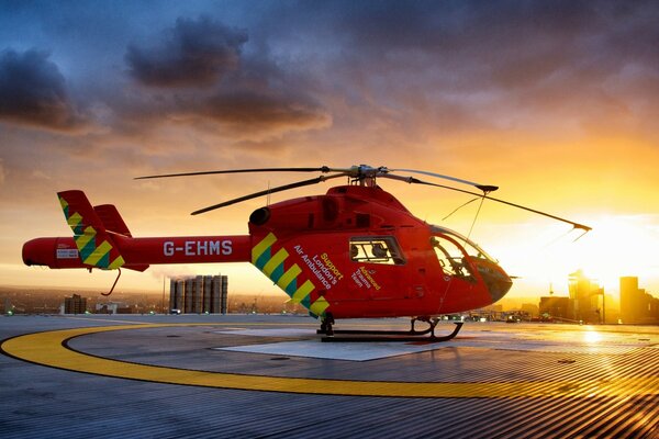 Helicopter on the silhouette of the city during sunset