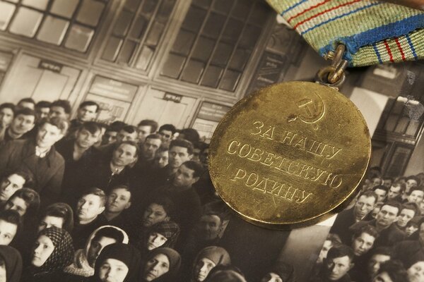 Medalla por nuestra patria Soviética en el fondo de una vieja foto de personas