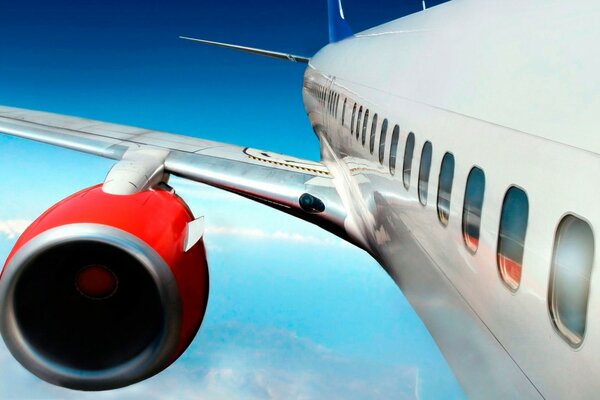 Der Passagier ist in einem solchen Flugzeug bequem mit Blick auf die rote Turbine am blauen Himmel zu fliegen