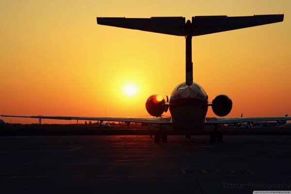 Silhouette eines Flugzeugs auf dem Hintergrund des Sonnenaufgangs