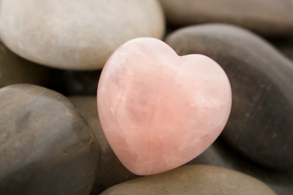 A pink stone heart among ordinary stones