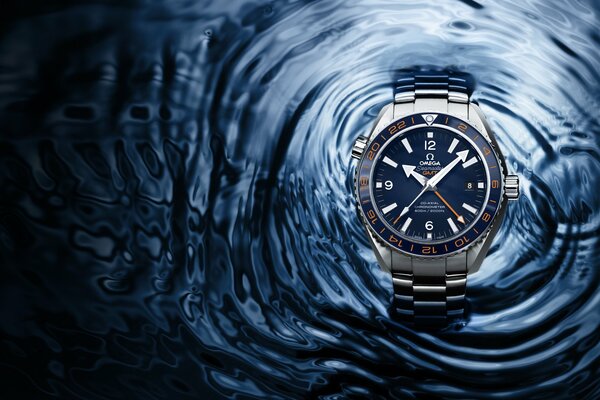 Omega-Uhr auf dem Hintergrund von Wasser mit Wellen