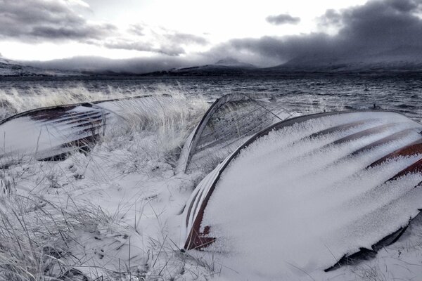 Bateaux sous la neige sur fond de ciel sombre