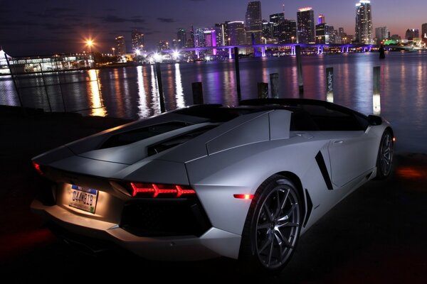 Auto in der Nacht am Fluss im Hintergrund der Stadt