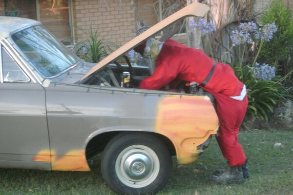 Foto von Santa an Weihnachten, der ein Auto repariert, holden
