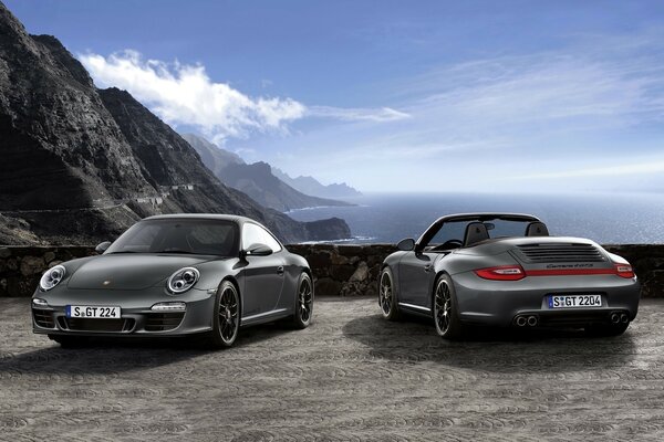 Porsche en medio de montañas y nubes azules