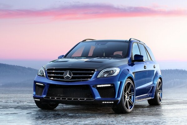 Blauer Mercedes Benz bei Sonnenuntergang am Strand