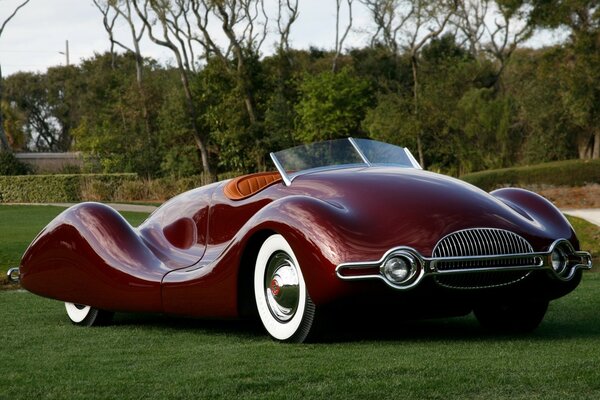 An unusual retro car is standing on the lawn