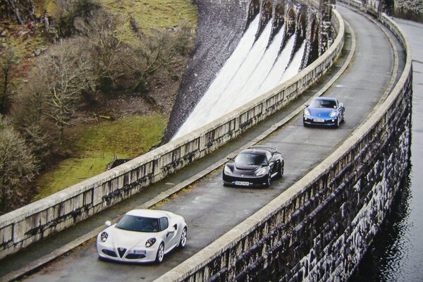 Sports cars on the road near the reservoir