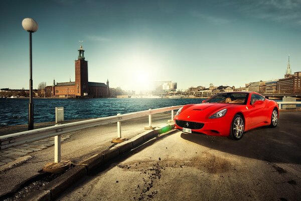 Rote Ferari auf dem Hintergrund des Flusses in der Stadt