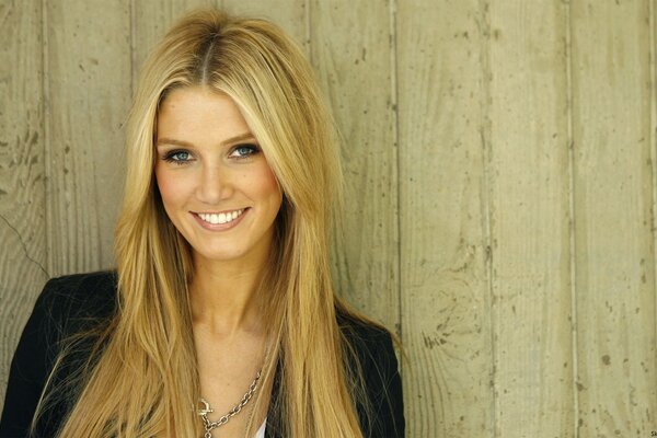 Sorriso di Delta Goodrem in posa su uno sfondo di tavole