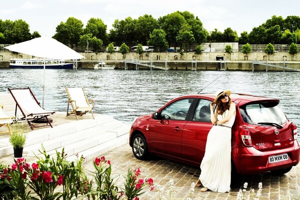 Chica y coche rojo cerca del río