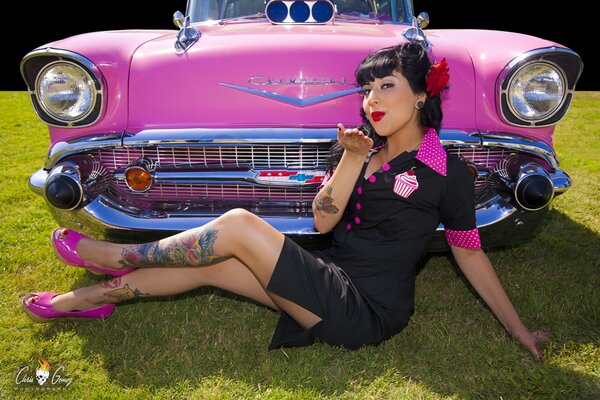 Dziewczyna z tatuażami obok różowego samochodu Chevroleta