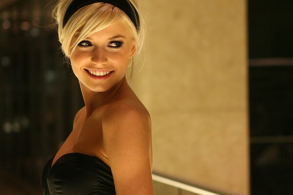 Photo of a smiling blonde in a black dress