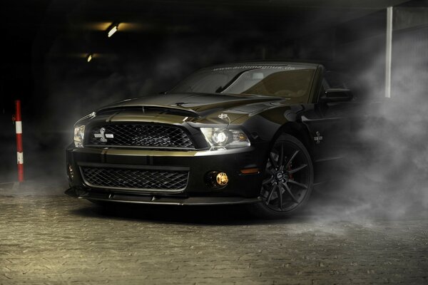 Black Ford Mustang car in the fog in the garage